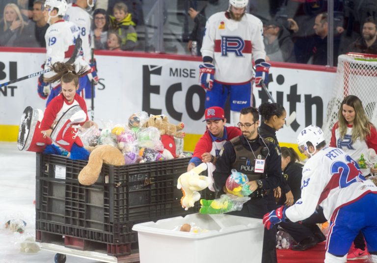 Il pleut des toutous à la Place Bell Les joueurs ramassent les toutous. On voit les pieds de la mascotte Cosmo dépasser du bac à peluches.