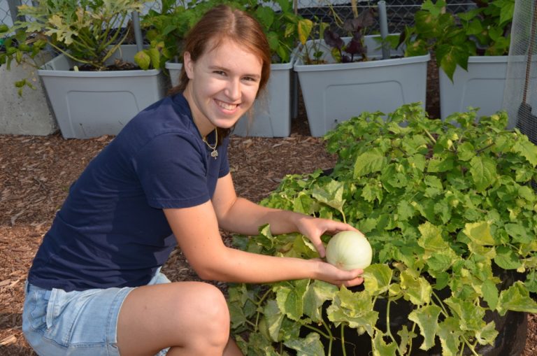 Béatrice exhibe un melon de miel.