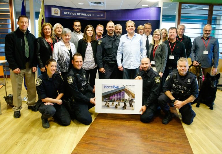 Partenaires, membres du corps policier lavallois, Nicole Desjardins (3e à gauche, rangée du milieu), mère de Martin Matte, et son fils Christian (au centre), victime d'un traumatisme crânien en 1986, se sont réunis le 24 octobre pour dévoiler le calendrier 2018 de l'équipe des maîtres-chiens.