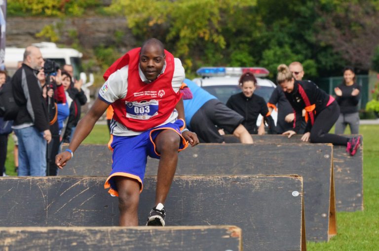 Défi relevé pour des policiers et athlètes bien spéciaux Alban Ndongbou, athlète des OSQ, a épaté les membres de son équipe par son agilité et son endurance. En arrière-plan, on aperçoit la journaliste Josianne Desjardins qui peine à surmonter un obstacle de petite envergure.