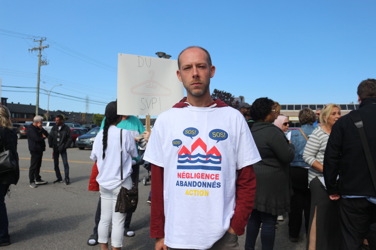 Le Lavallois Steve Beauchamp, victime des inondations du printemps à sa résidence secondaire de Pierrefonds, pose devant une pancarte où on peut lire «Du support SVP».