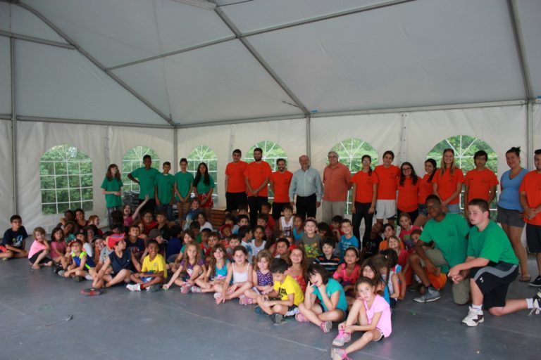 Messieurs François Pilon, député de Laval-Les Îles et Jacques Coiteux, directeur général adjoint de la Corporation Centre du Sablon sont entourés des jeunes du camp de jour et des moniteurs et monitrices. 