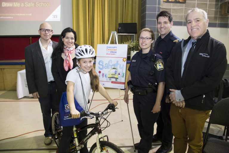 Xalia Bisbikos, gagnante du concours de dessin au sein de la Commission scolaire Sir-Wilfrid-Laurier, est entourée de ses parents, de même que Lyne Chartier, agente au Service de police de Laval, Frédéric Jean, sergent, et Réal Grégoire, de la Société de l’assurance automobile du Québec.