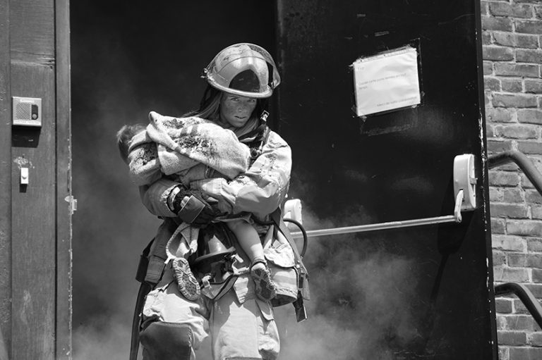 Deux causes et un calendrier pour les pompières Juliane Jalbert sauve un bambin des flammes dans la page de novembre du calendrier.(Photo gracieuseté – Martin Alarie)