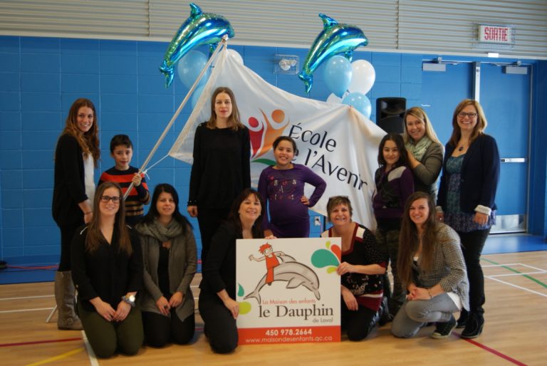 Les jeunes de l'école l'Avenir, Luka Frias, Maria Moussa et Angelina Mkrtchian posent en compagnie de la directrice de l'école Louise Ouellette, de la directrice de la Maison des enfants le Dauphin, Stéphanie Leblanc, ainsi que plusieurs partenaires et amis de l'organisme communautaire.