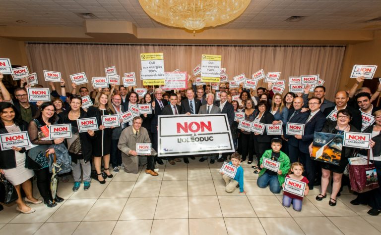 Le maire Marc Demers entouré de Patrick Bonin de Greenpeace, du cardiologue et spécialiste en santé environnementale François Reeves et de nombreux Lavallois opposés au projet de l'oléoduc Énergie Est, lors du dépôt du mémoire de Laval à la Commission de l'environnement de la CMM, le 29 septembre.